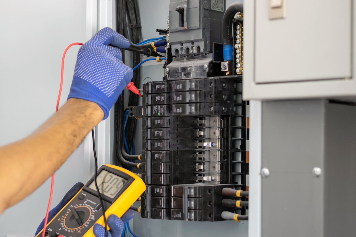 Pro Max electrician testing a panel during an aluminum-wiring inspection
